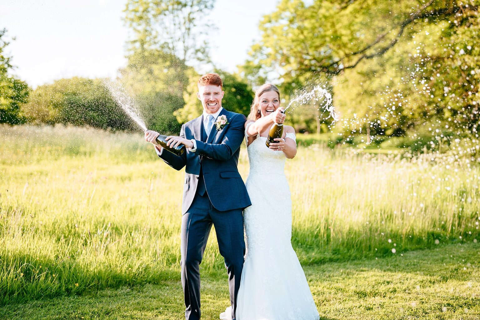 bride and groom spray champagne