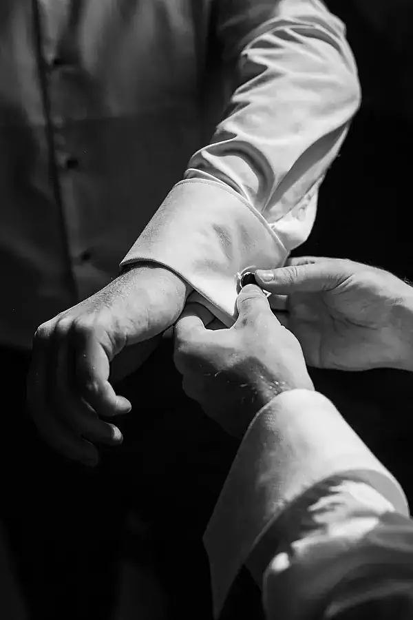 Are you VAT registered - black and white shot of groom fastening cuff links
