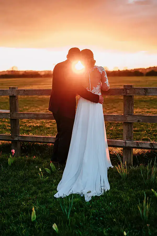 Bride and groom staring out at a sunset